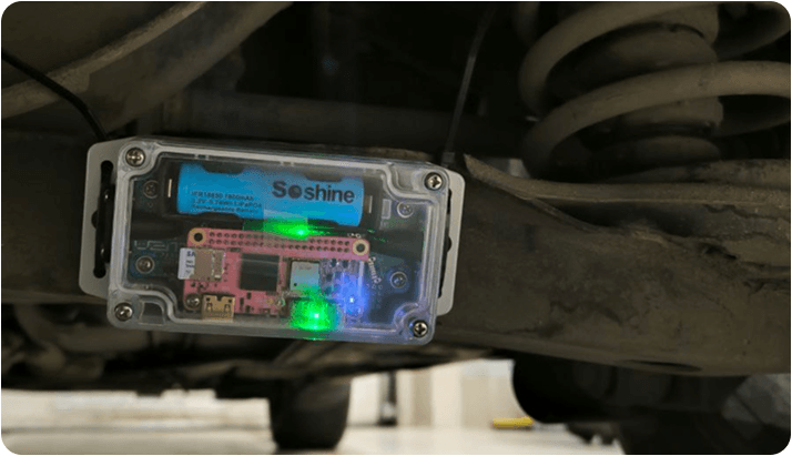 V2M-One prototype with a Mango Pi Zero board and battery, mounted beneath a vehicle