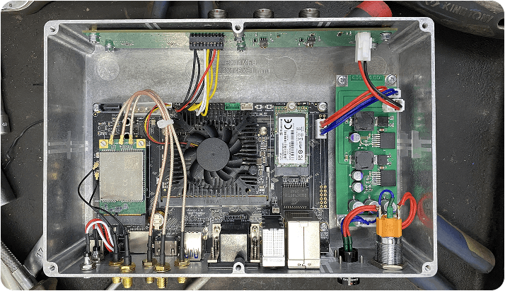 Open metal enclosure of the 2021 V2M-One prototype, showing its circuit boards, wiring and cooling fan